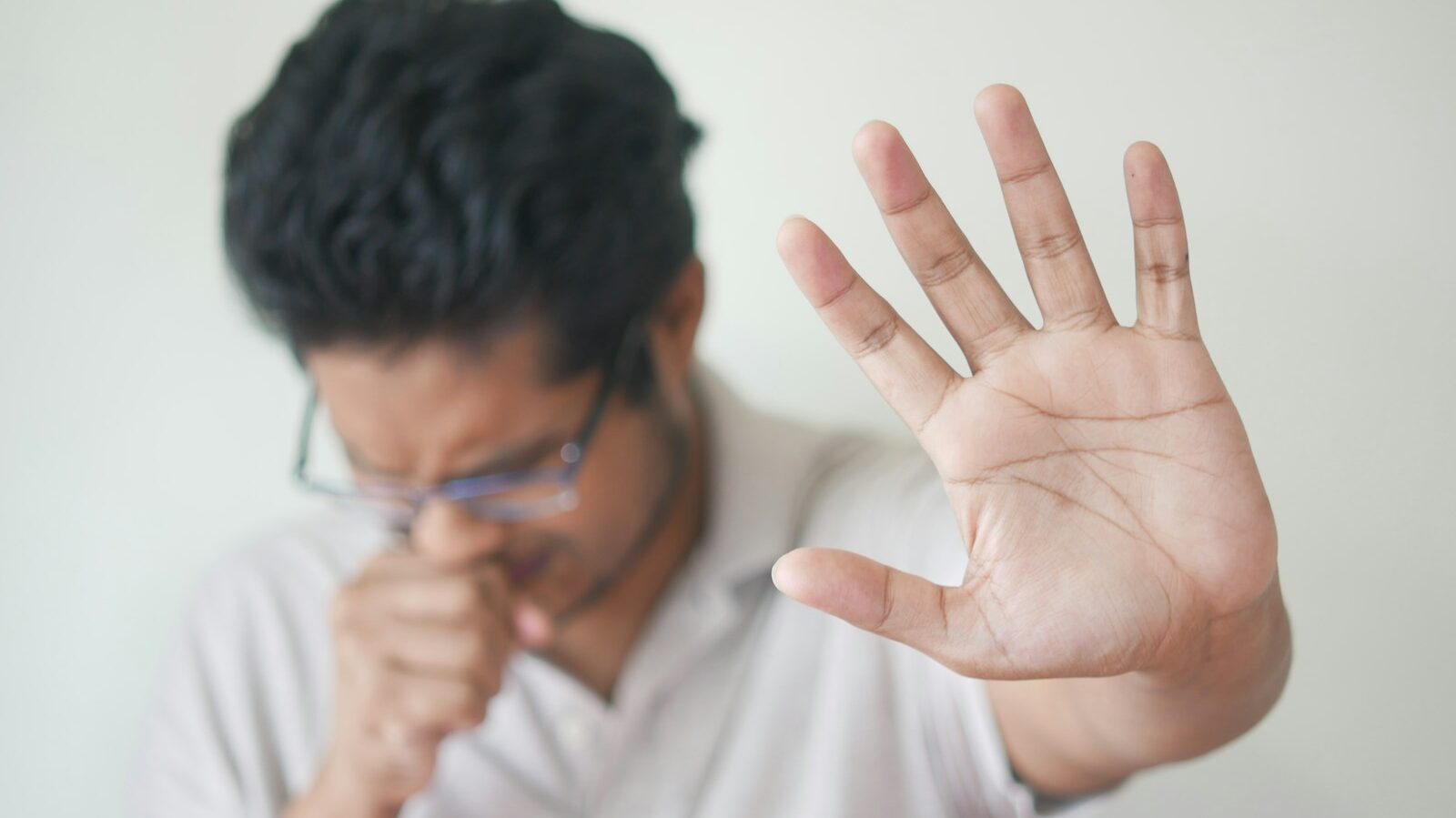 a man holding his hand up in front of his face