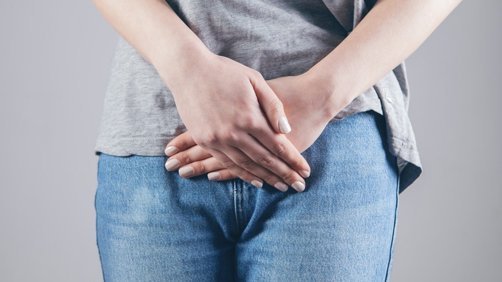 man in gray shirt and blue denim jeans