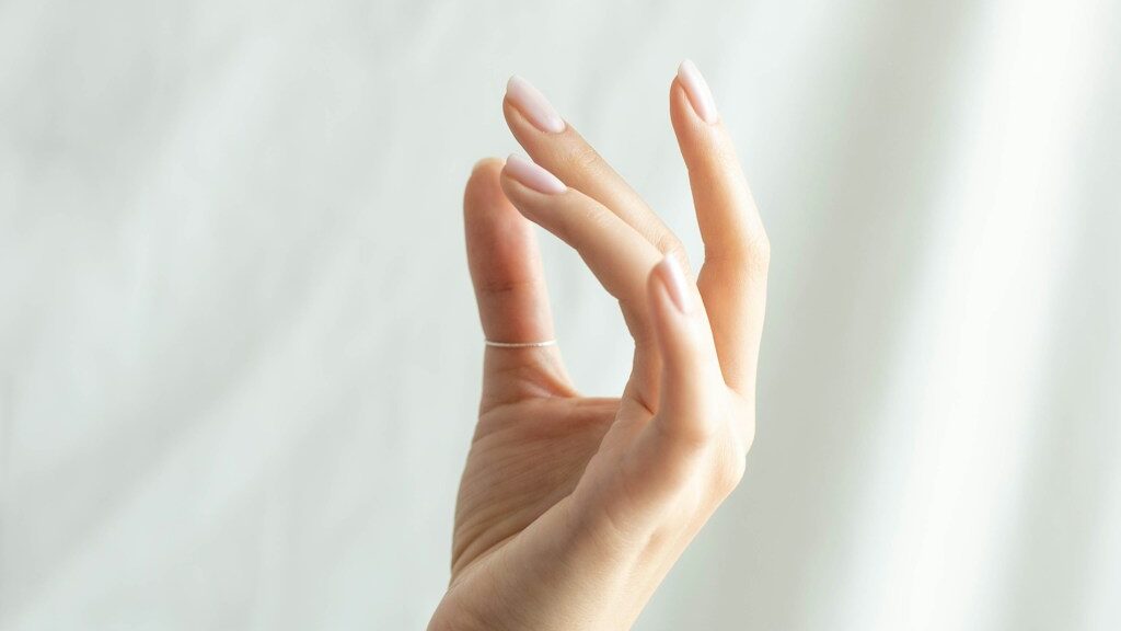 persons left hand on white textile