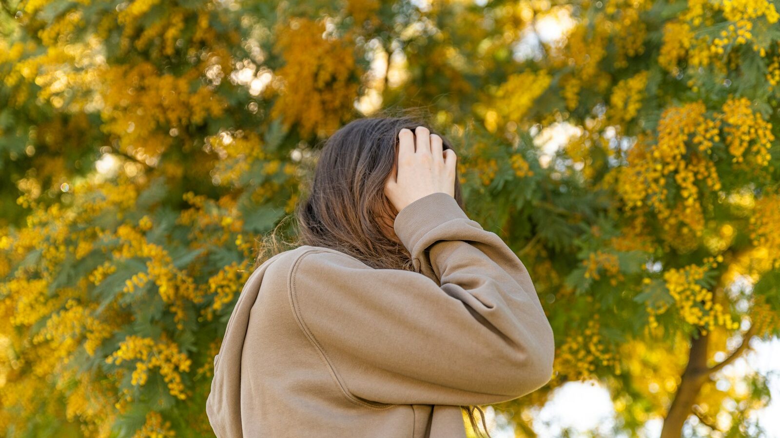 a woman covering her face with her hands